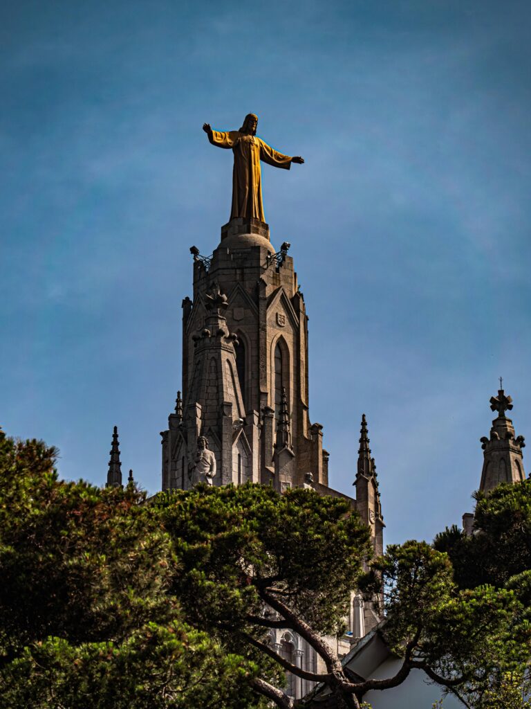 A statue of Christ emerging above the trees in one of the best neighborhoods to live in Barcelona