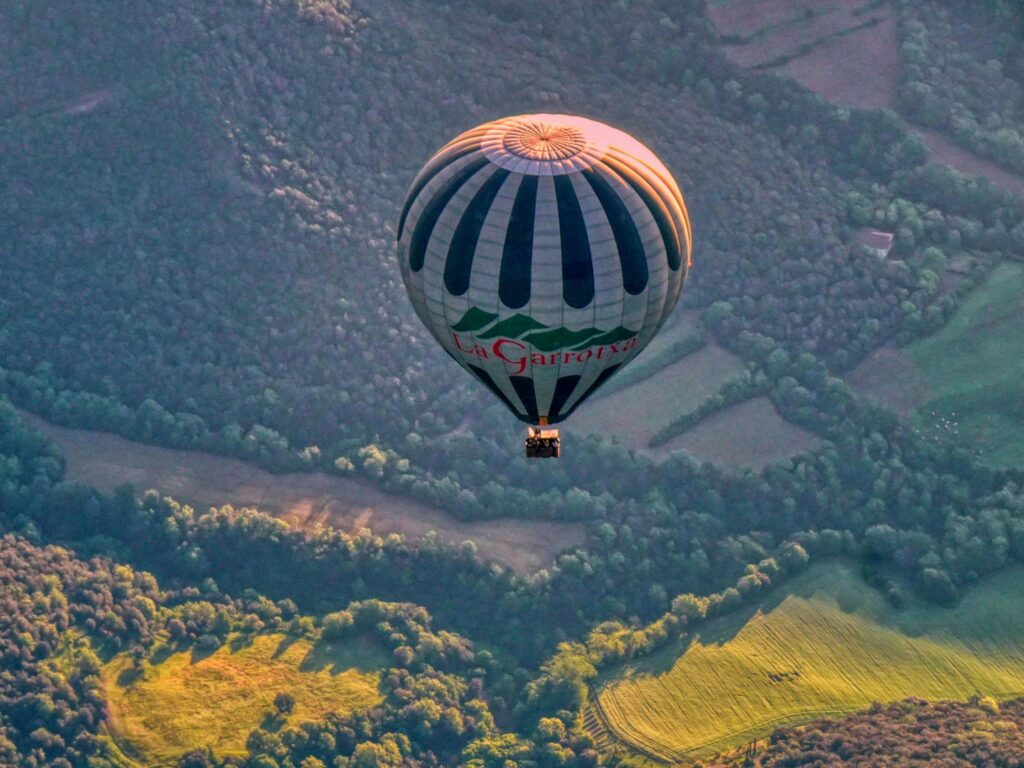 A hot air balloon floating over the landscape of Santa Pau, in the beautiful La Garrotxa region.