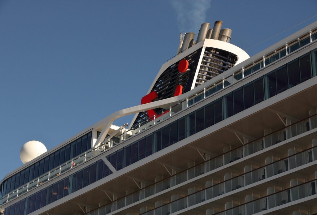 The towering side of a massive cruise ship docked in the Port of Barcelona, representing the scale of mass tourism that fuels discussions around **anti-tourism protests in Barcelona**.